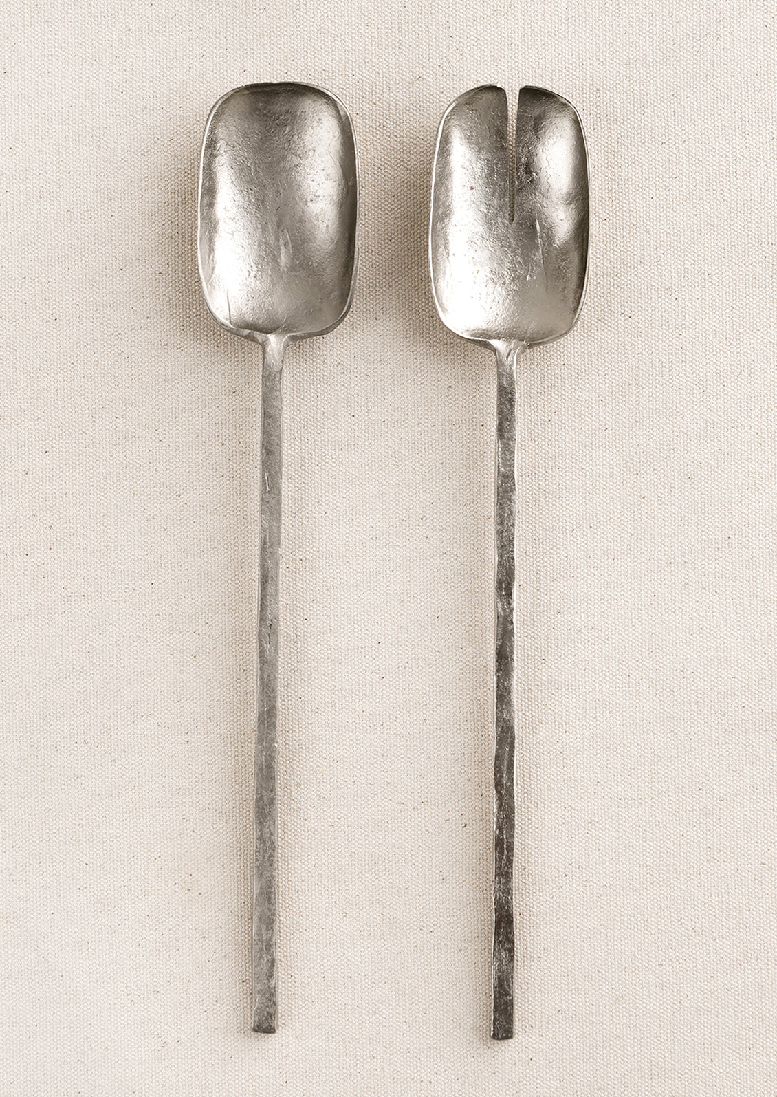 Two piece salad serving set in a primitive silhouette, made in natural unpolished pewter finish.