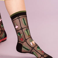 Black: Sheer black nylon socks with multicolor veggie print.