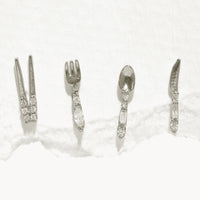 Silver: A set of four silver stud earrings in shape of chopsticks, fork, spoon, and knife.