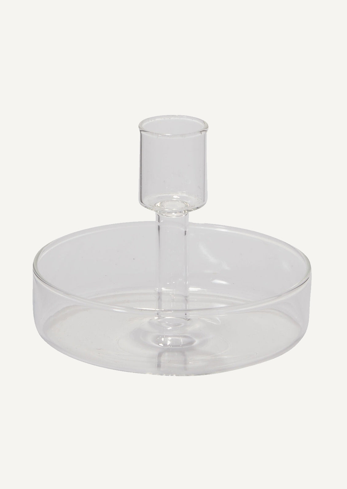 A clear glass candleholder with saucer-like base for catching drips.