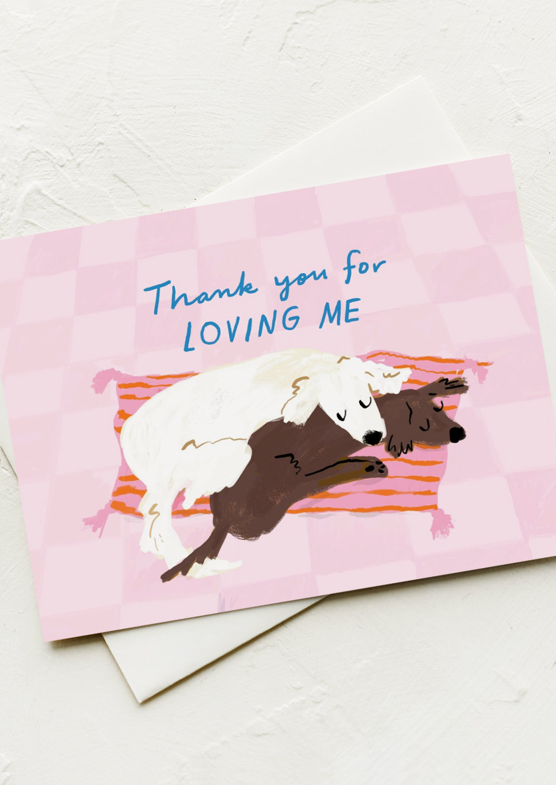 A greeting card with illustration of two snuggling dogs, text reads "Thank you for loving me".