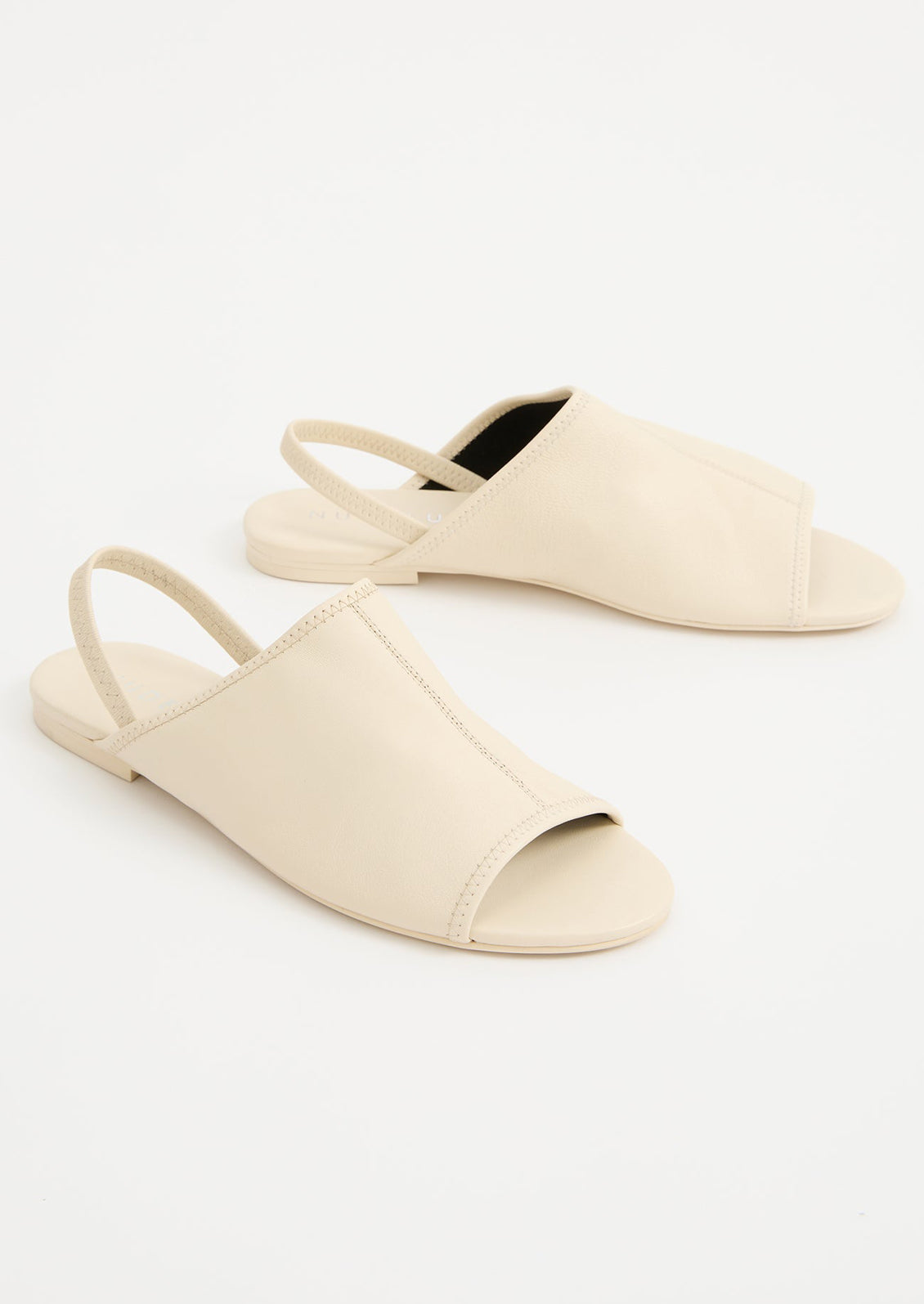 A pair of cream leather open toe, slingback flat sandals.