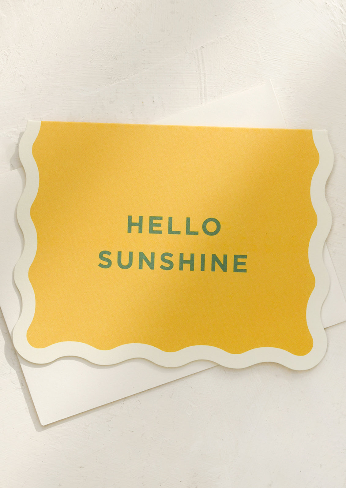 A yellow card with green lettering reading "Hello Sunshine".