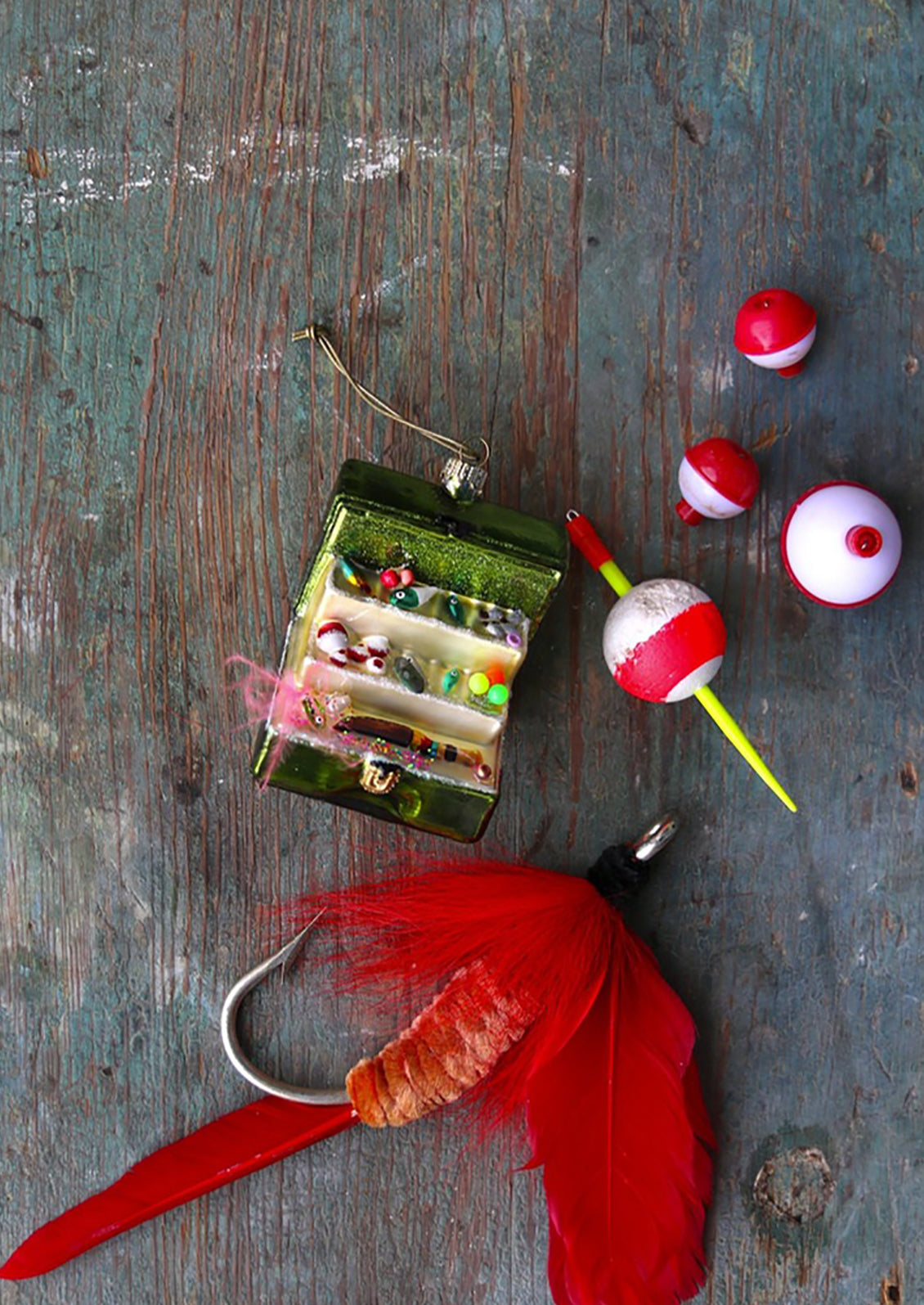 A holiday ornament of a fishing tackle box with fishing supplies.