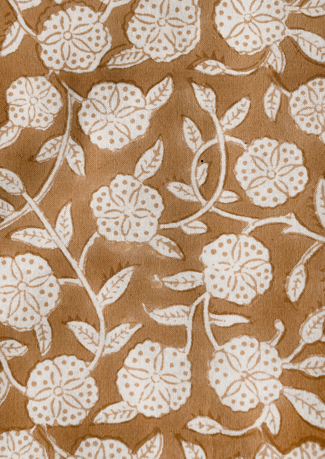 A block printed tablecloth in brown and white floral motif.
