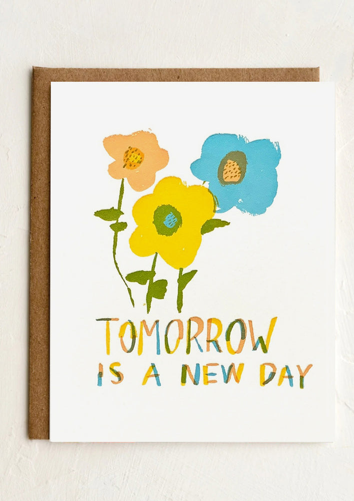 A flower print card reading "tomorrow is a new day".