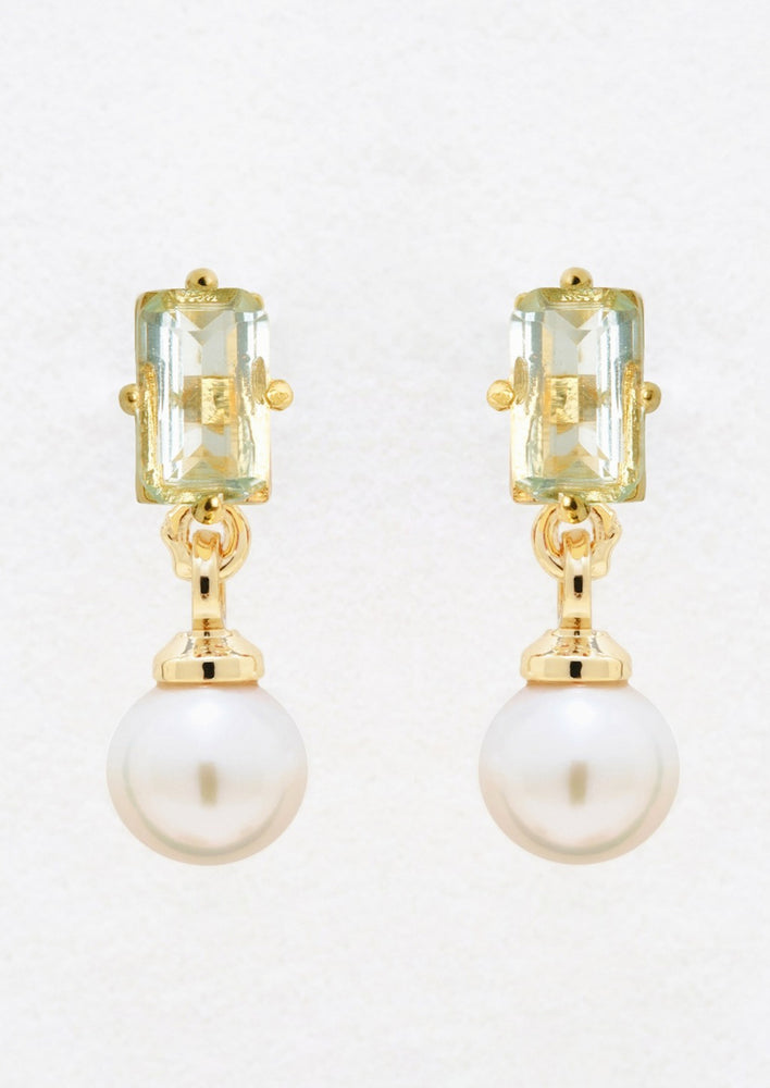 A pair of gold studs with baguette blue topaz and dangling pearl.
