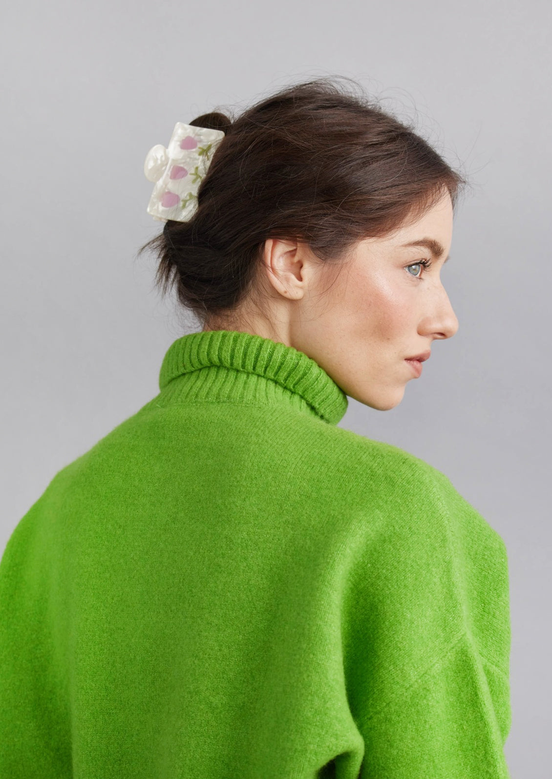 A rectangular hair claw with pearl finish with pink tulip design.