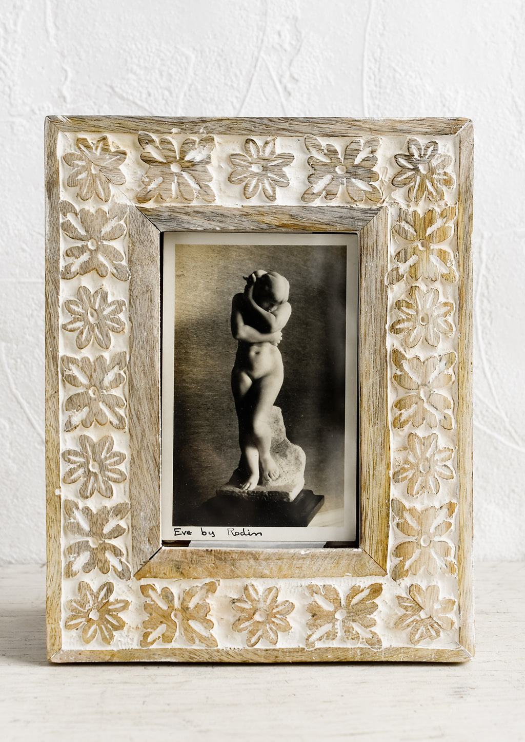 1: A wooden picture frame with carved whitewash floral design.