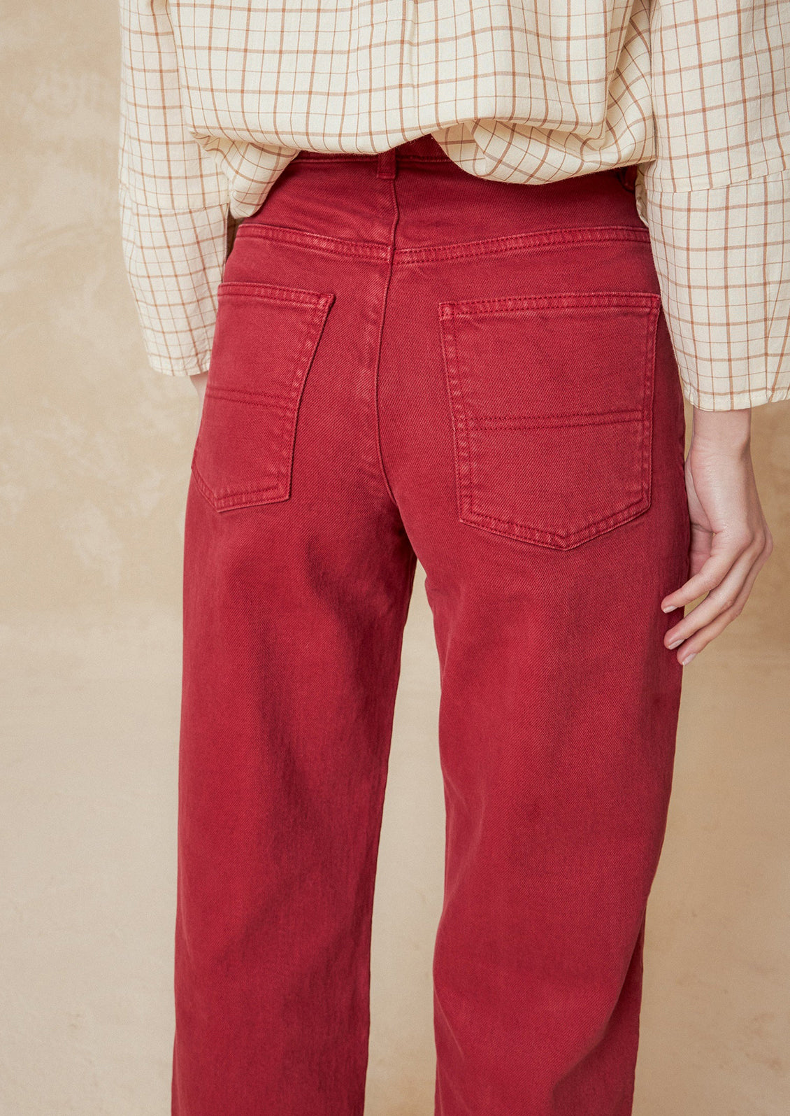 A pair of red wide leg jeans with vertical seam down front.