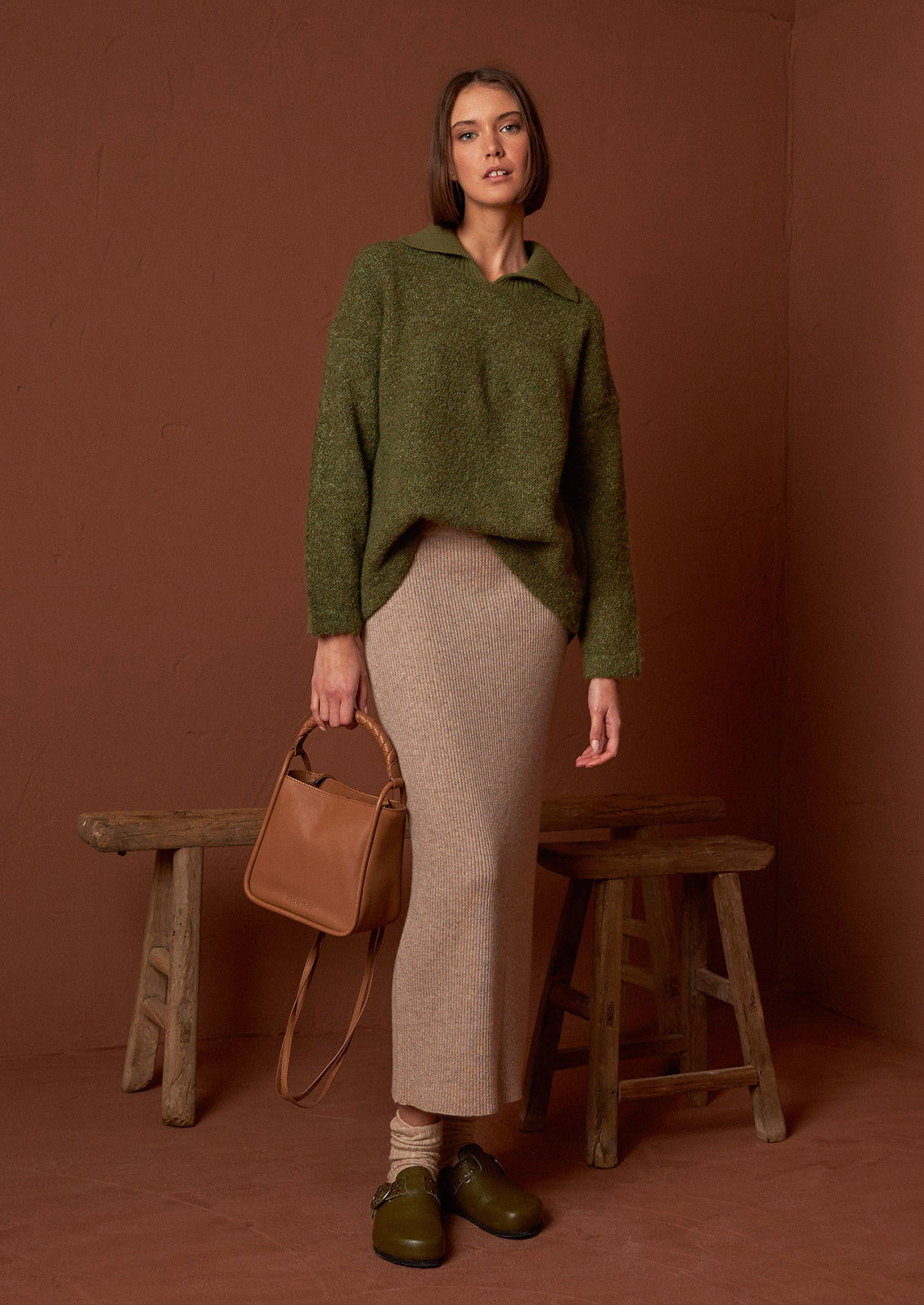 A woman wearing a polo collar fuzzy army green sweater.