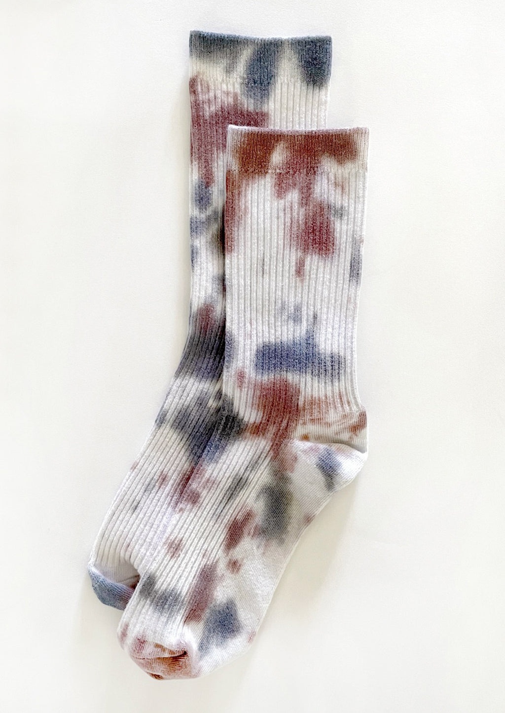 Western: A pair of tie dye socks in white with maroon and blue.