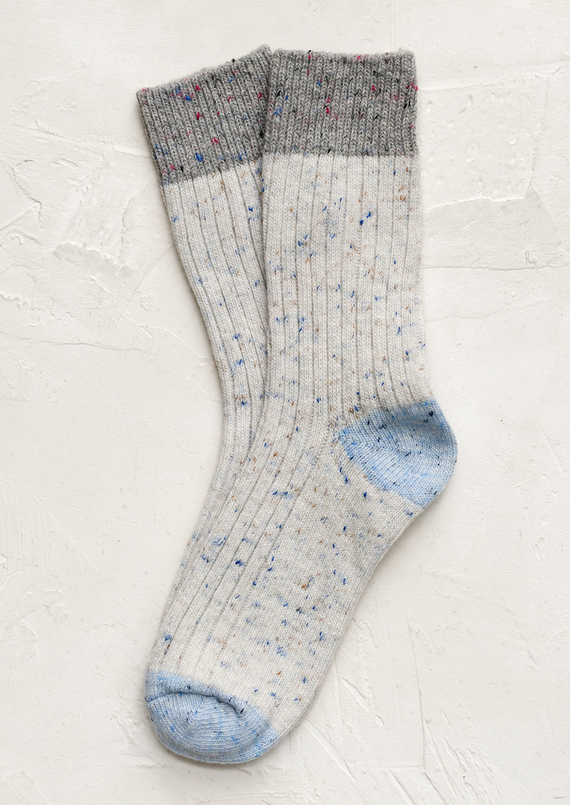A pair of white socks with grey and blue contrast.