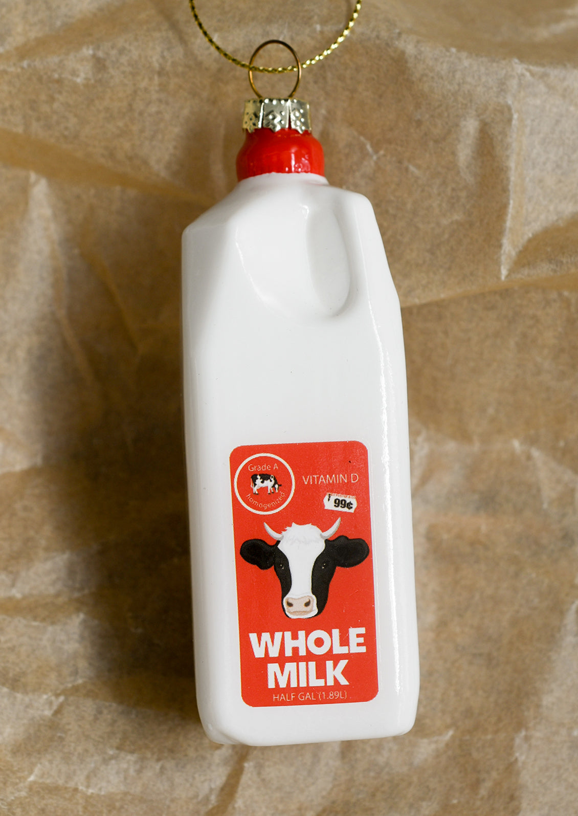 A glass ornament depicting a carton of whole milk.