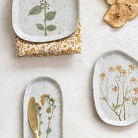 2: Ceramic plates in asymmetrical shapes with wildflower patterns.