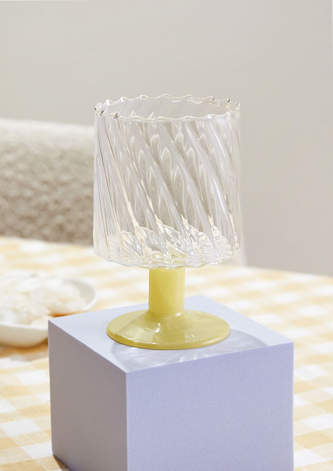 A fluted wine glass with opaque yellow glass stem.