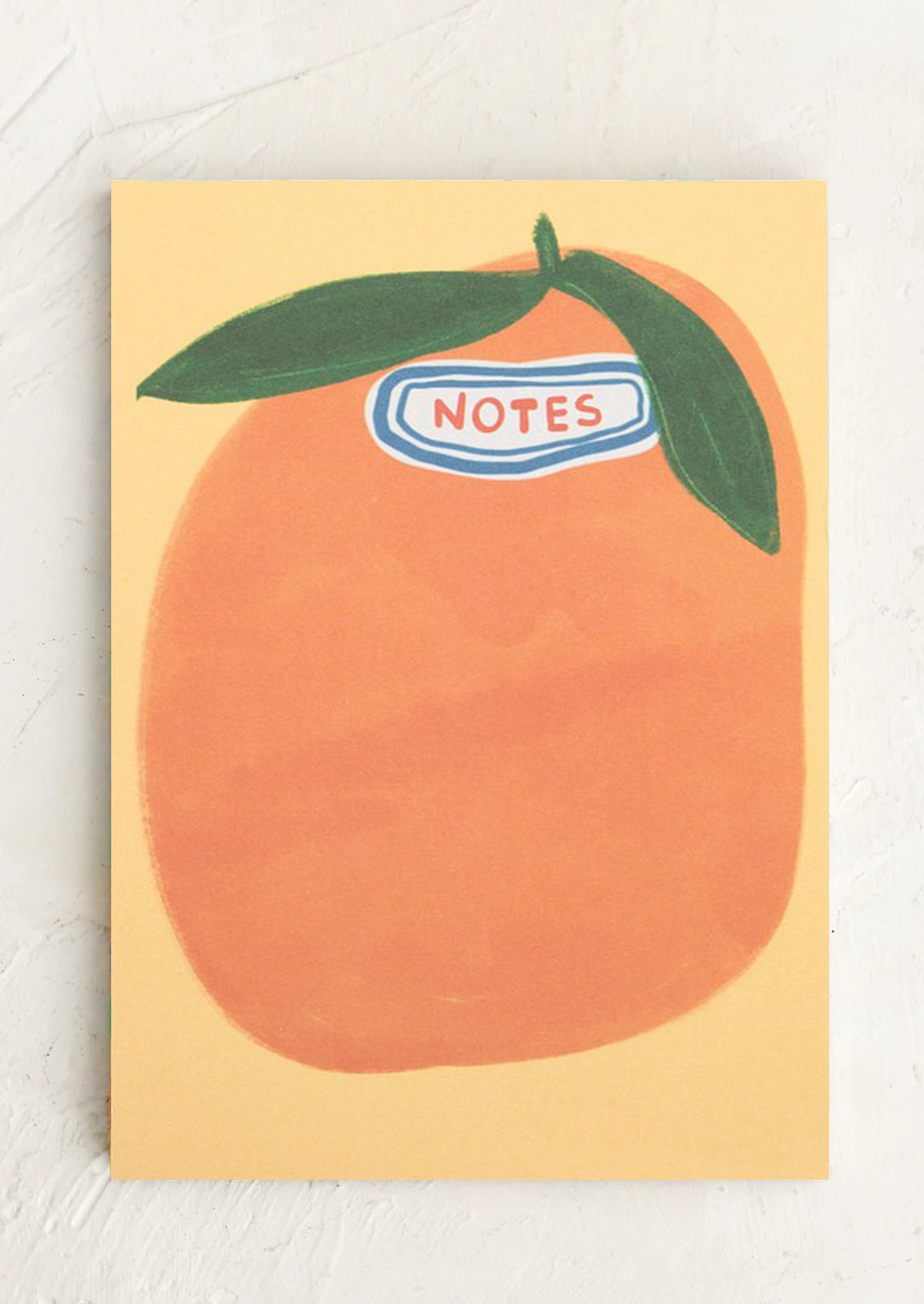 Notepad with an orange design and 'Notes' label on a light background