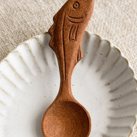 1: A wooden spoon with a handle carved in the shape of a fish.