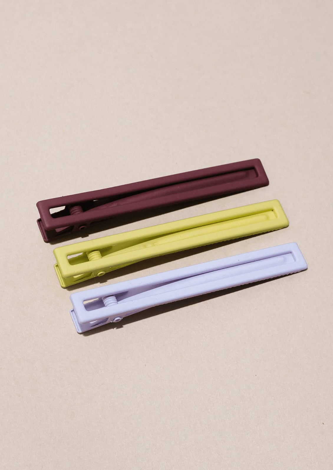 A set of three bar-shaped hair clip sets in yellow, fig and lavender.