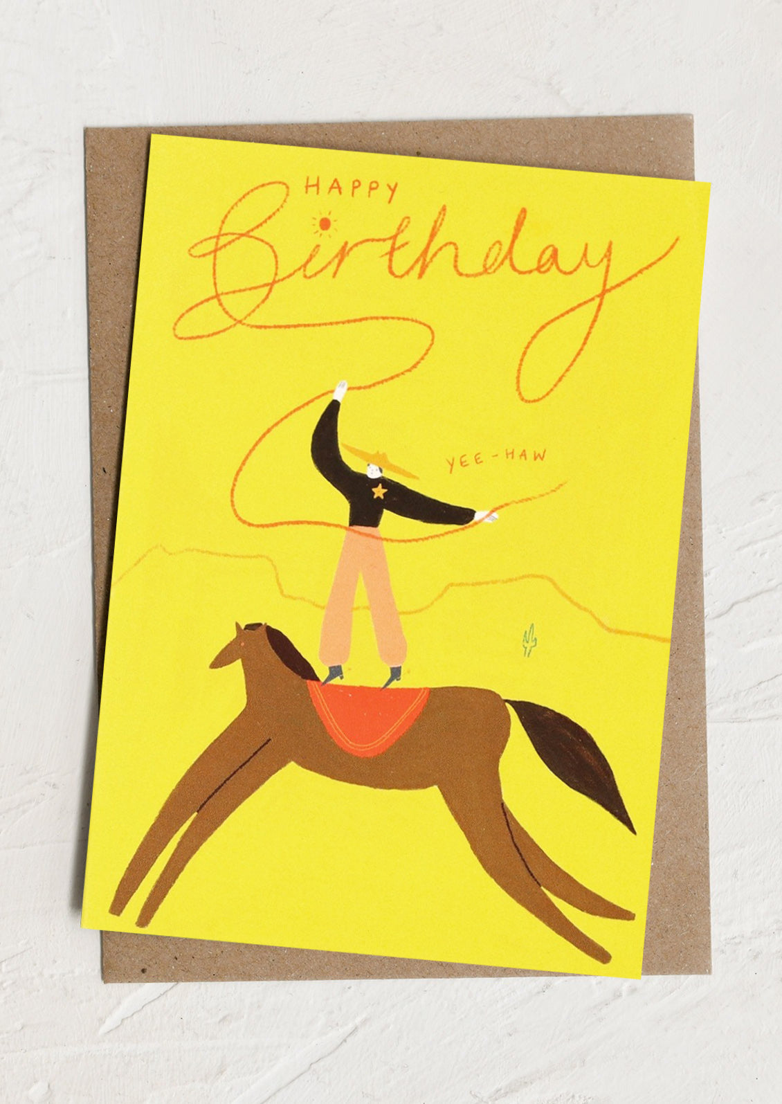 Birthday card with illustration of a person on a horse and 'Happy Birthday' text on a yellow background.