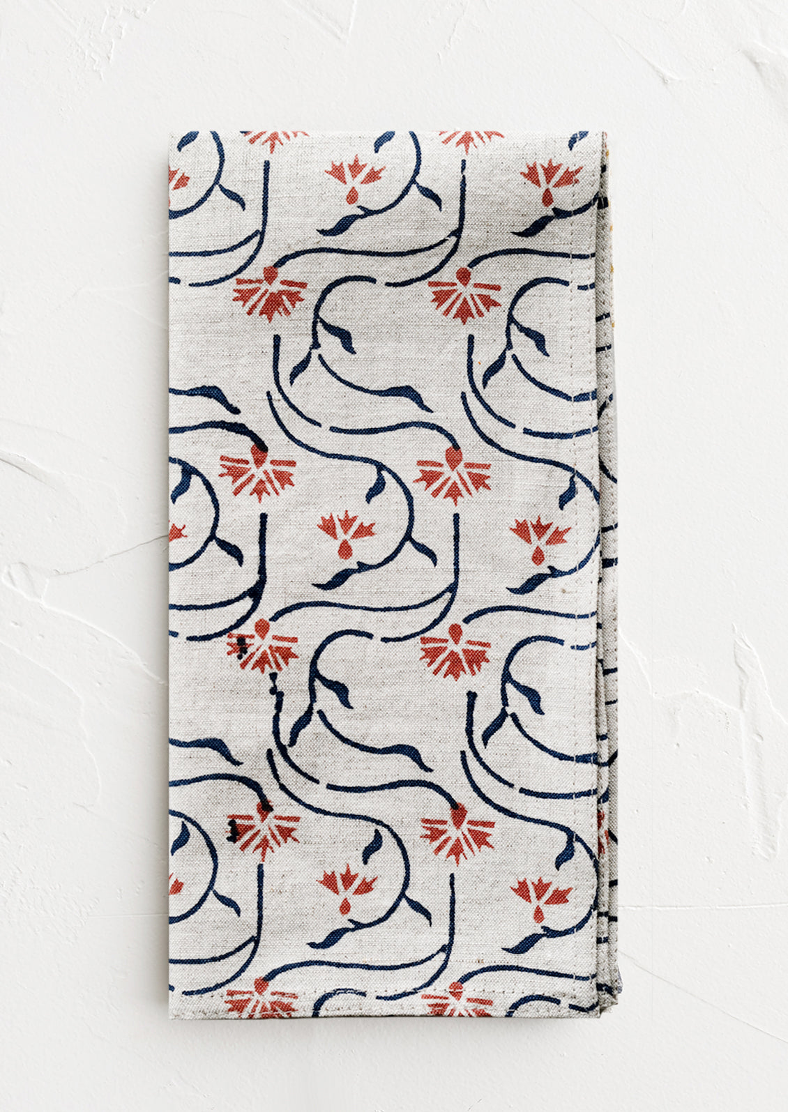 A block printed linen napkin with floral line print.