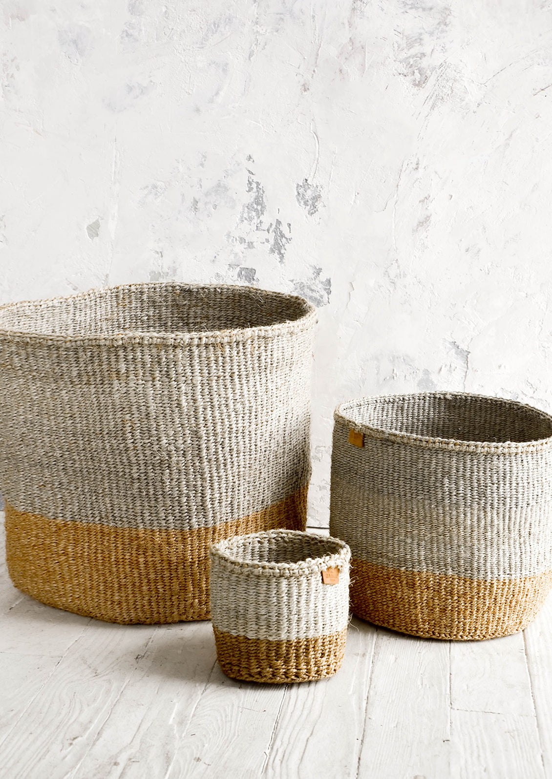 Three storage baskets woven from sisal in grey & natural two tone design. Shown in three incremental sizes.