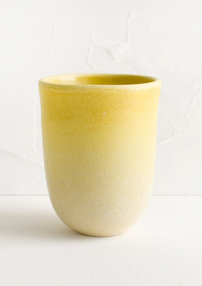 A ceramic cup with gradient yellow glaze.
