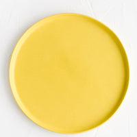 1: A round ceramic dinner plate in sun yellow.