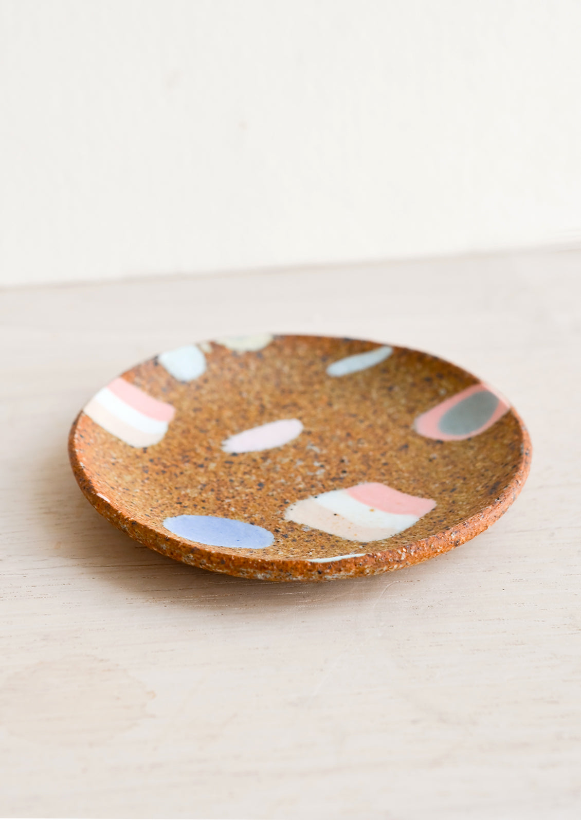 Ceramic trinket dish with various inlay shapes.