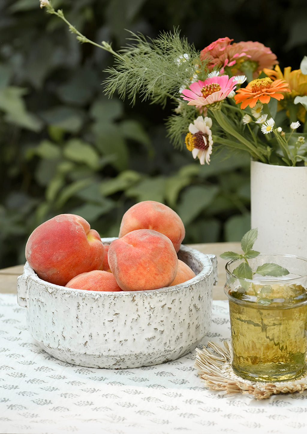 Medium: A textured ceramic bowl on a table, holding peaches.