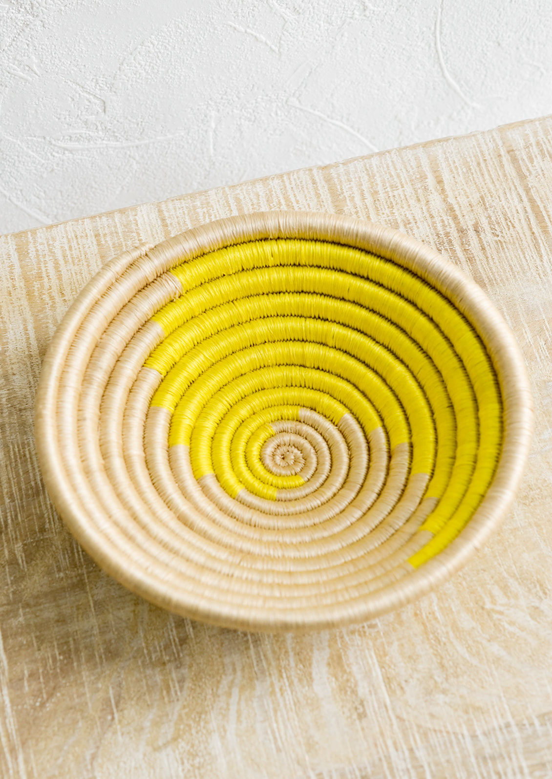 A sweetgrass catchall bowl in tan and sun yellow.