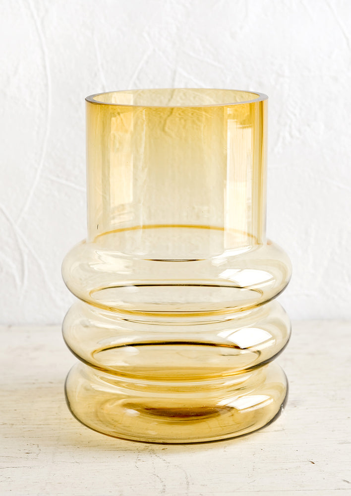 1: An amber tinted glass vase in a curved design.