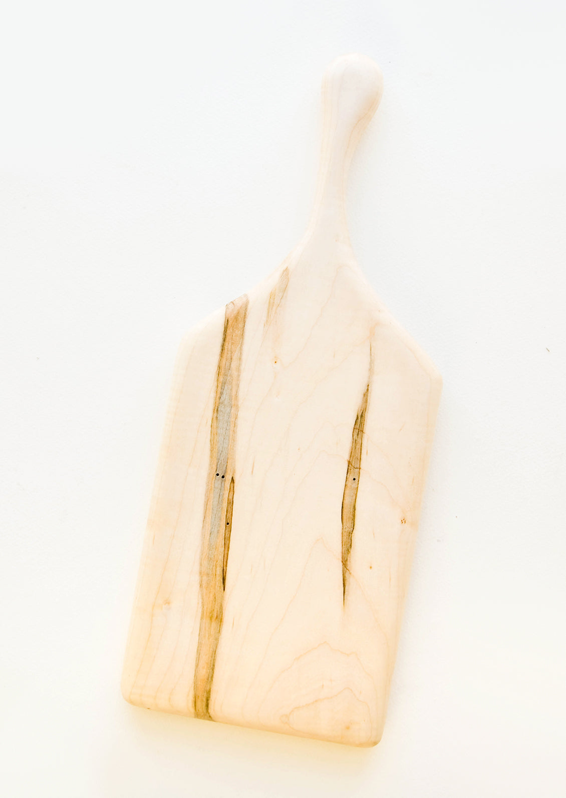 A short rectangular pale wood cutting board with handle.