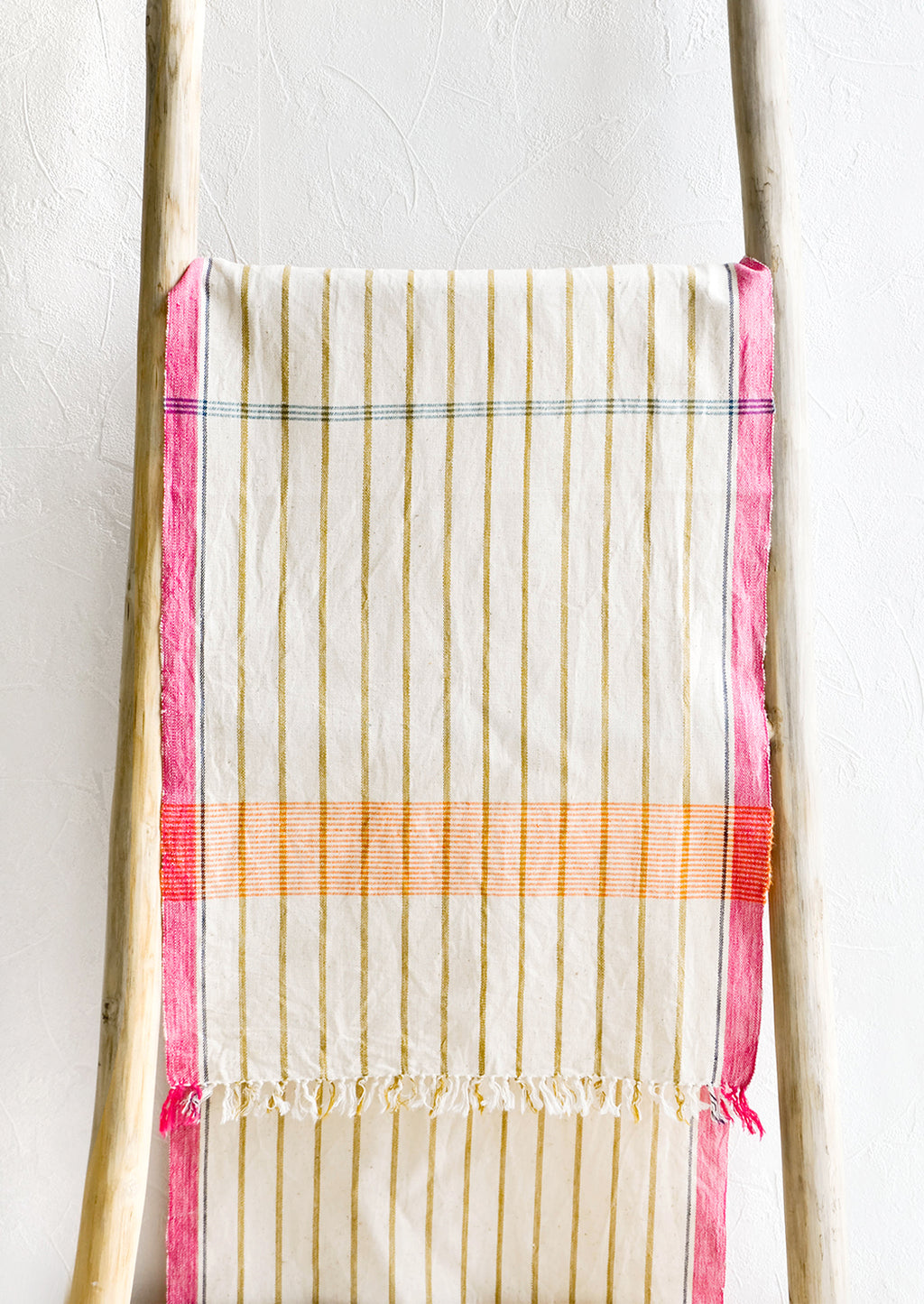 2: Brightly colored cotton table runner displayed on wooden ladder