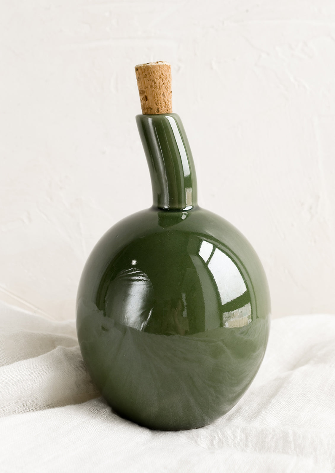 A glossy green ceramic cruet bottle with asymmetrical, bulbous silhouette.