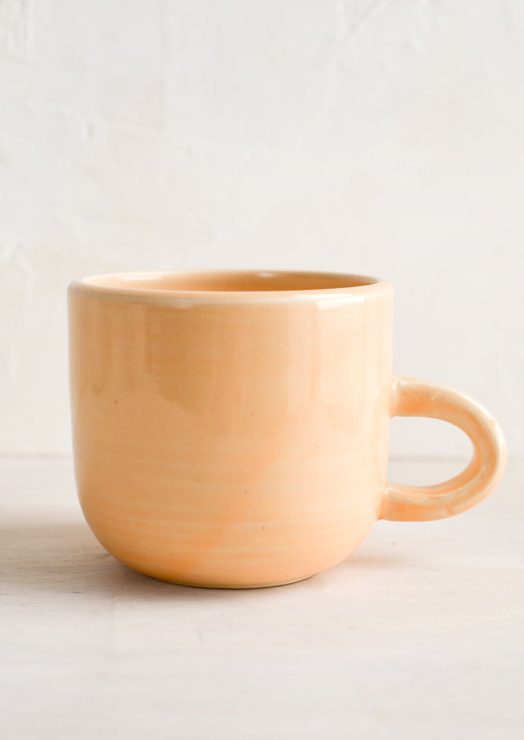 Nectar (Glossy): A short ceramic coffee mug in glossy pastel peach glaze.