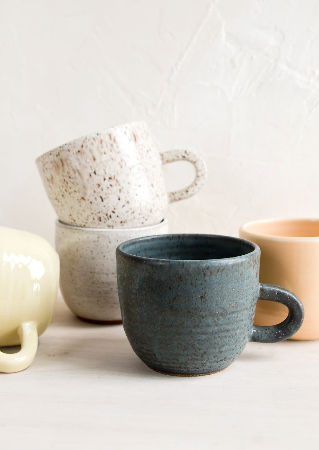 3: A stack of ceramic mugs in a mix of glazes and colors.