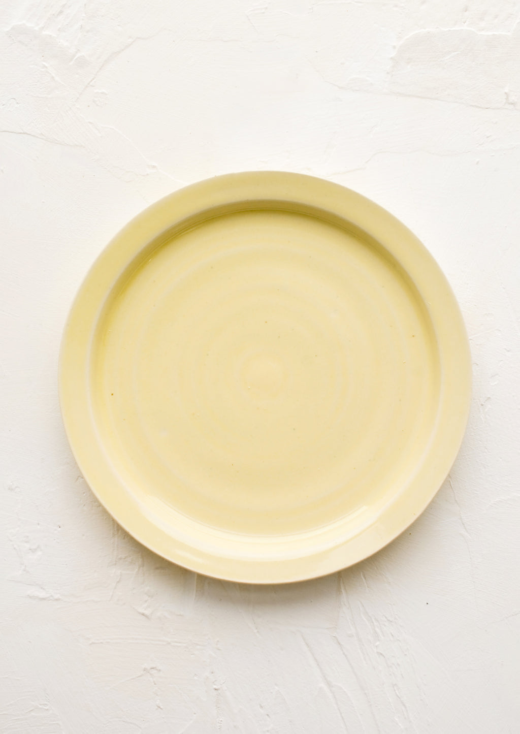 Butter (Glossy): A ceramic side plate in glossy butter yellow glaze.