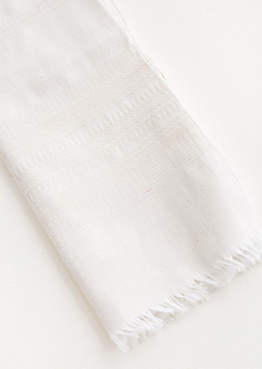 Unbleached: A white cotton towel with fringed edge.