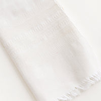 Unbleached: A white cotton towel with fringed edge.
