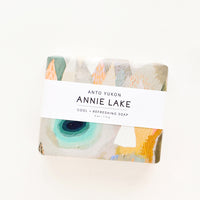 Annie Lake: A bar of soap in multicolored packaging with a white horizontal label.