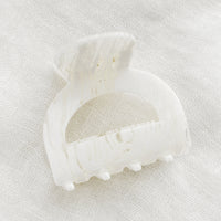 Spun White: An arch shaped hair claw in spun white.