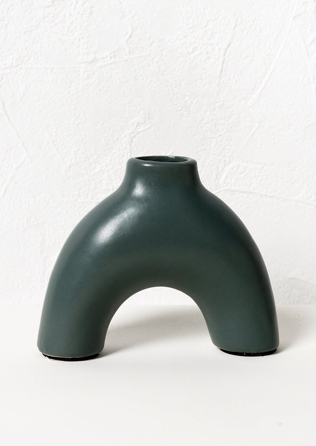 1: An arch shaped ceramic vase in teal color.