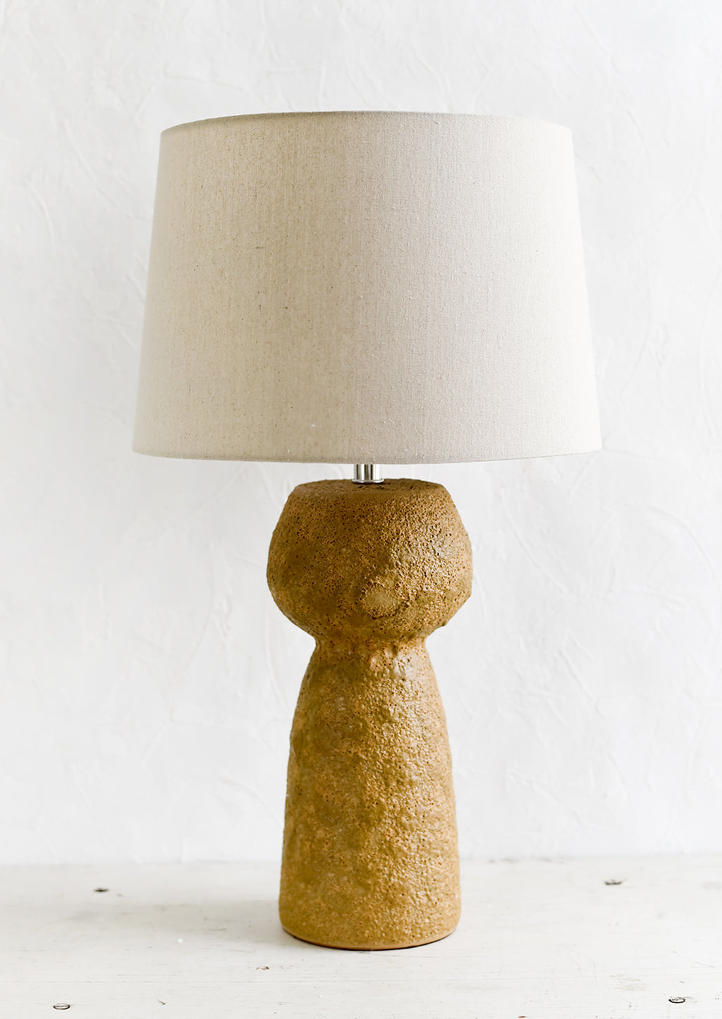 1: A textured brown stoneware table lamp.