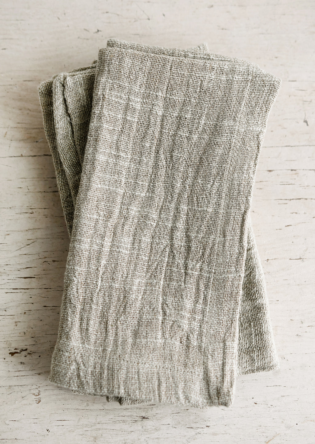 2: Slub textured linen-cotton napkins folded on a table.