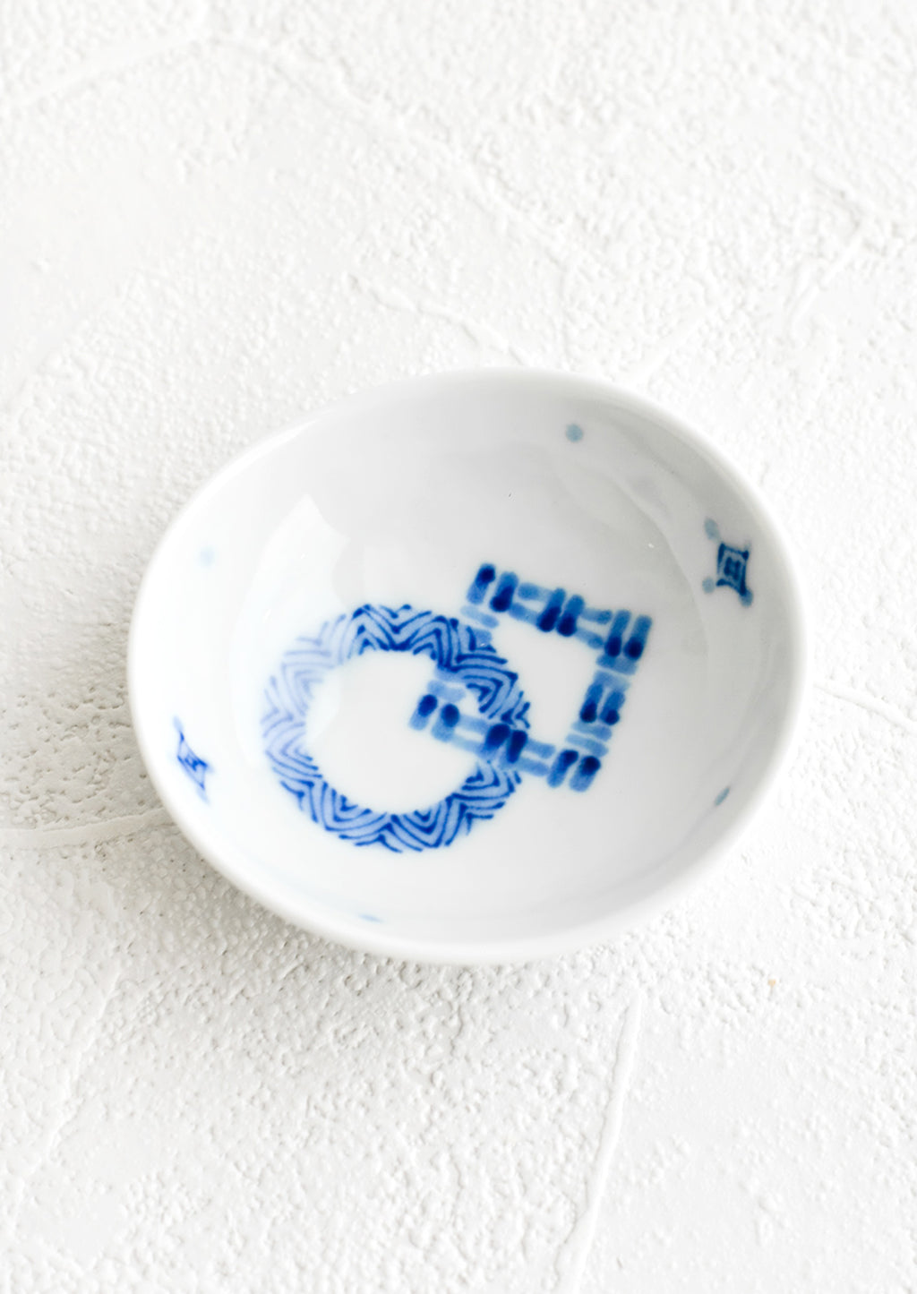 1: A round ceramic trinket dish with abstract pattern in blue.