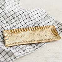 1: A rectangular ceramic butter plate on a tea towel.