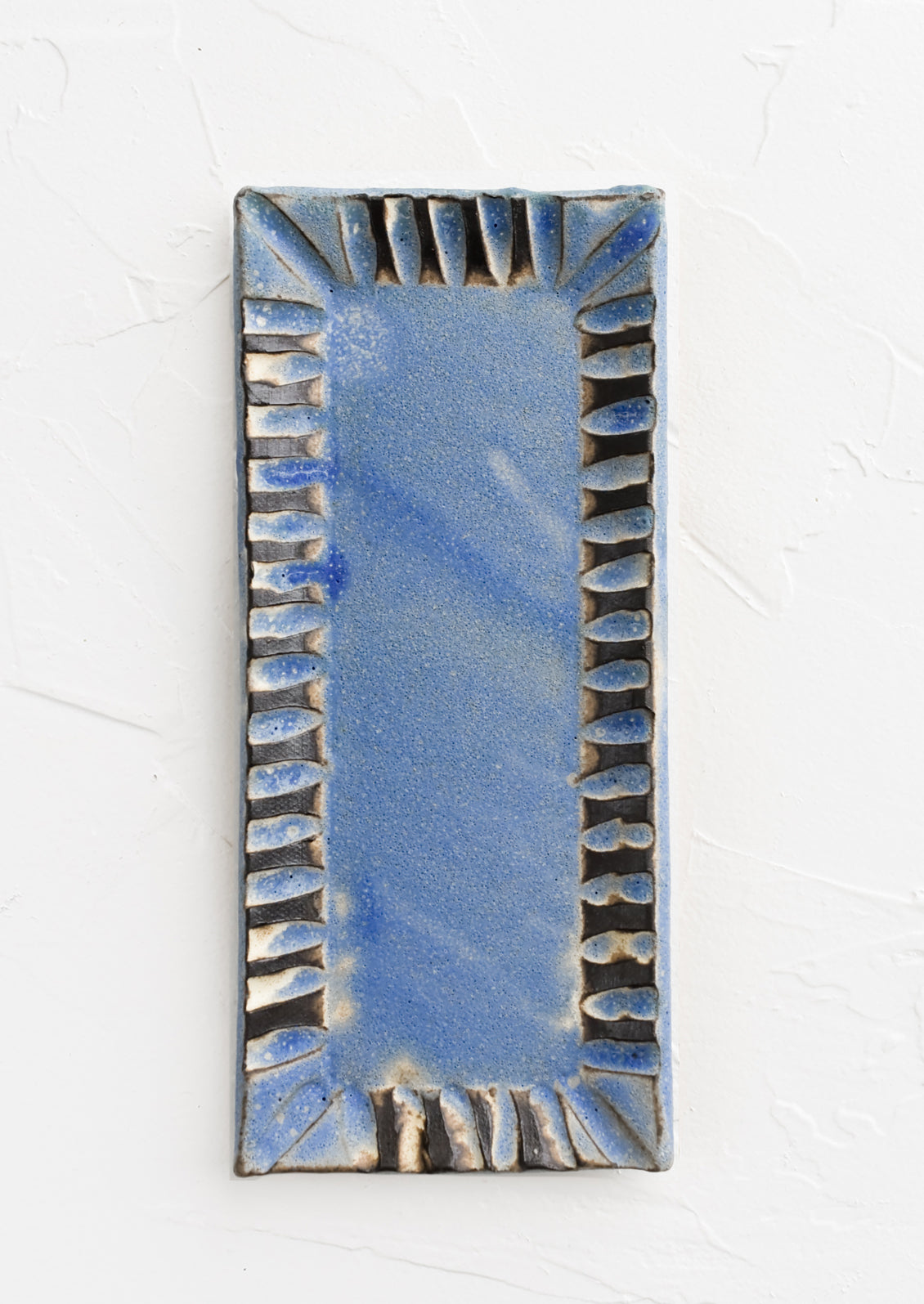 A rectangular ceramic butter dish with textured border in cornflower blue.