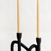 2: An asymmetrical taper holder in curved design, showing two taper candles.