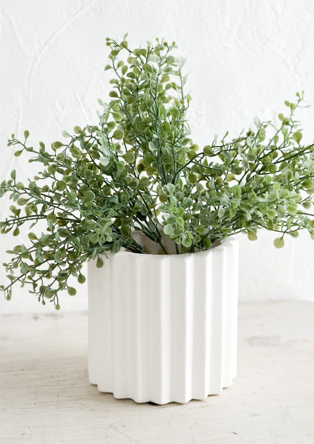 2: A geometric groove textured planter with plant.